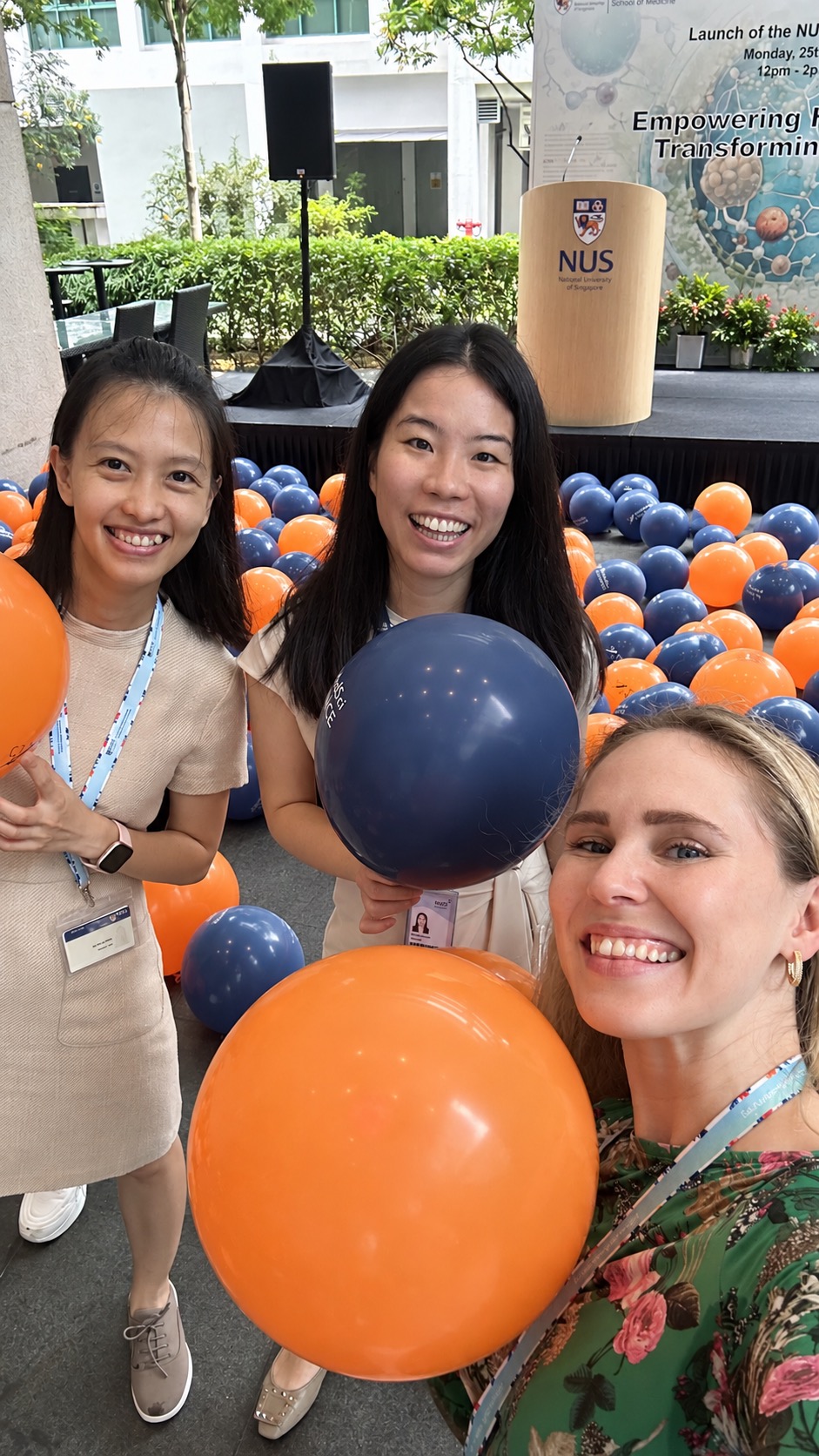 Three women smiling with balloons at the NUSMedSci Alliance launch